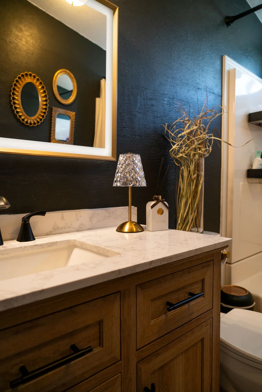 Bathroom vanity with a stone counter and framed mirror
