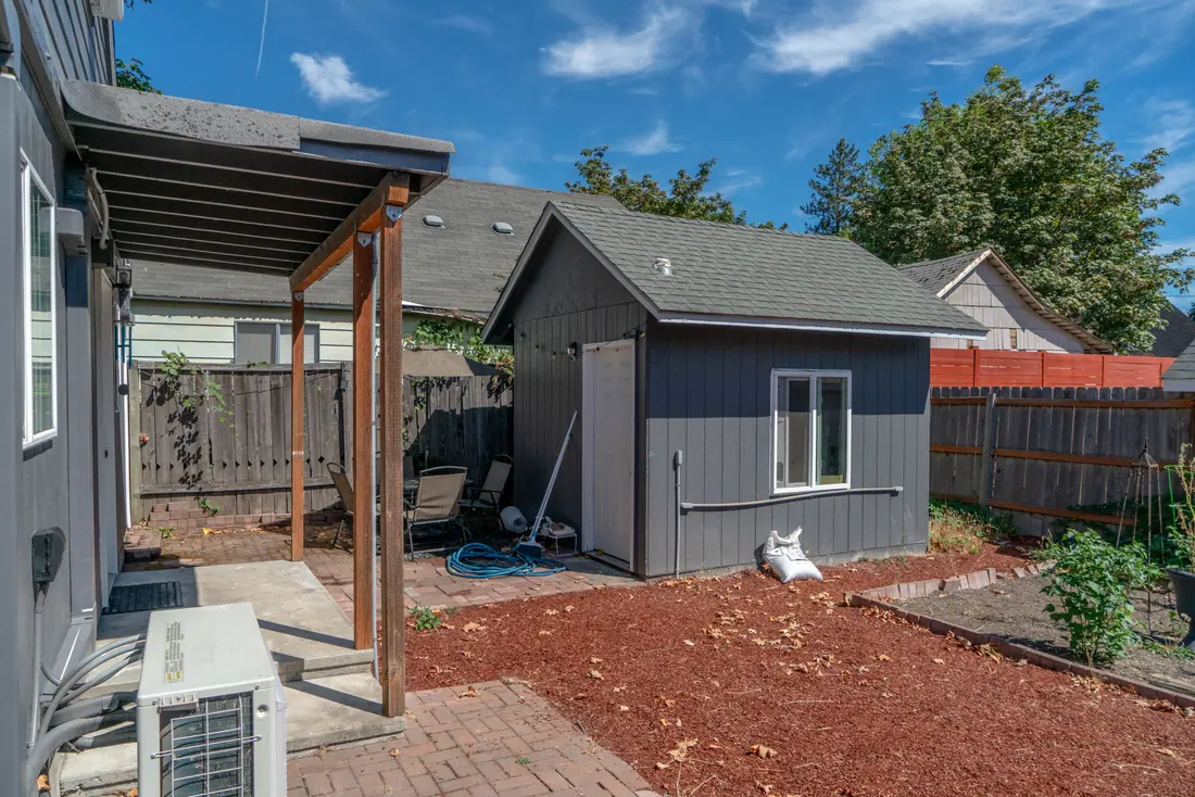 Rear of the house after repainting, with white window trim against dark siding