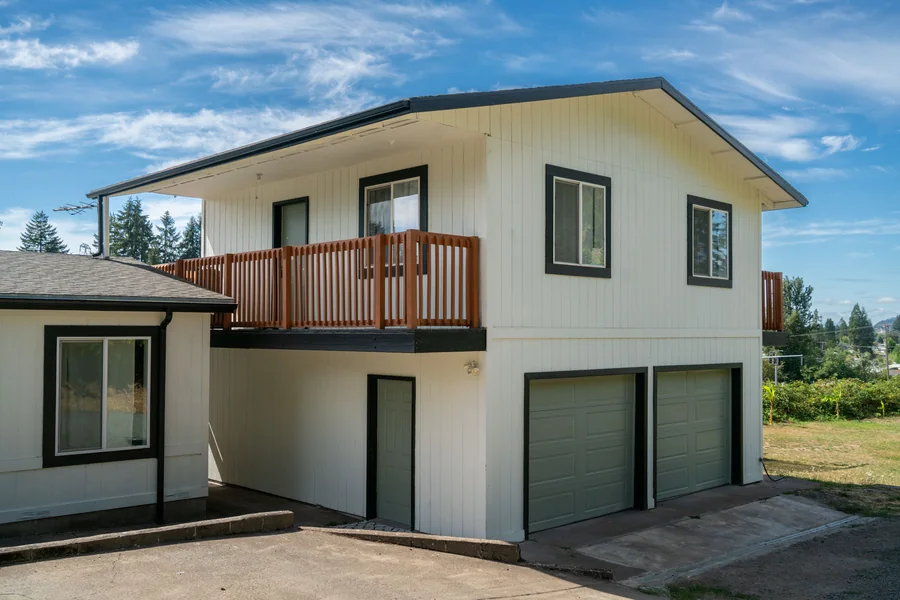 Two-storey house in white siding with black window trim