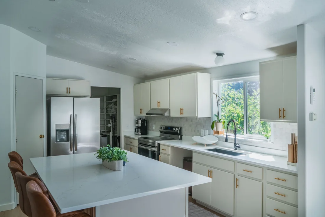 Finished kitchen with white cabinetry, a tiled backsplash and a window over the sink