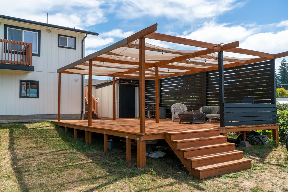 Cedar deck with a pergola and steps down to the lawn