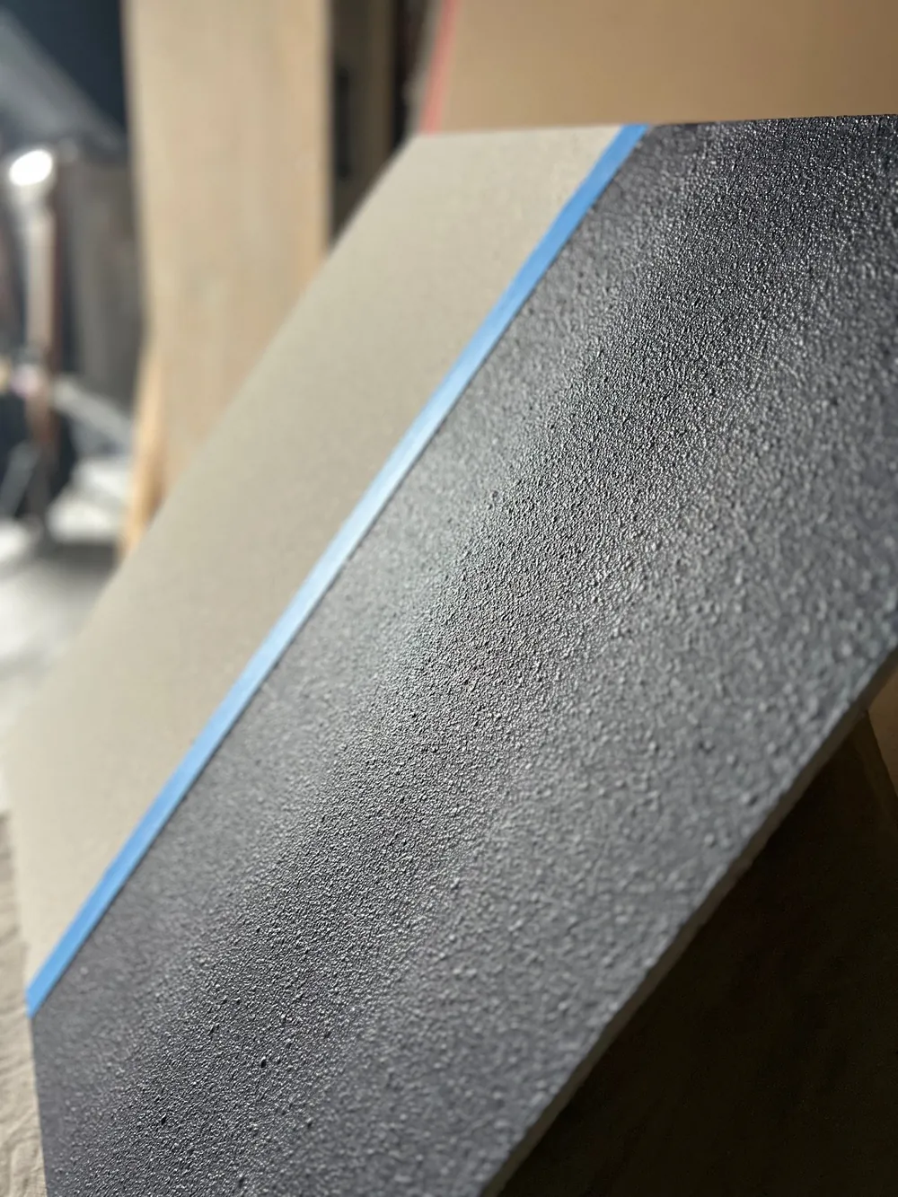 Smooth level-five finish sample beside a taped edge