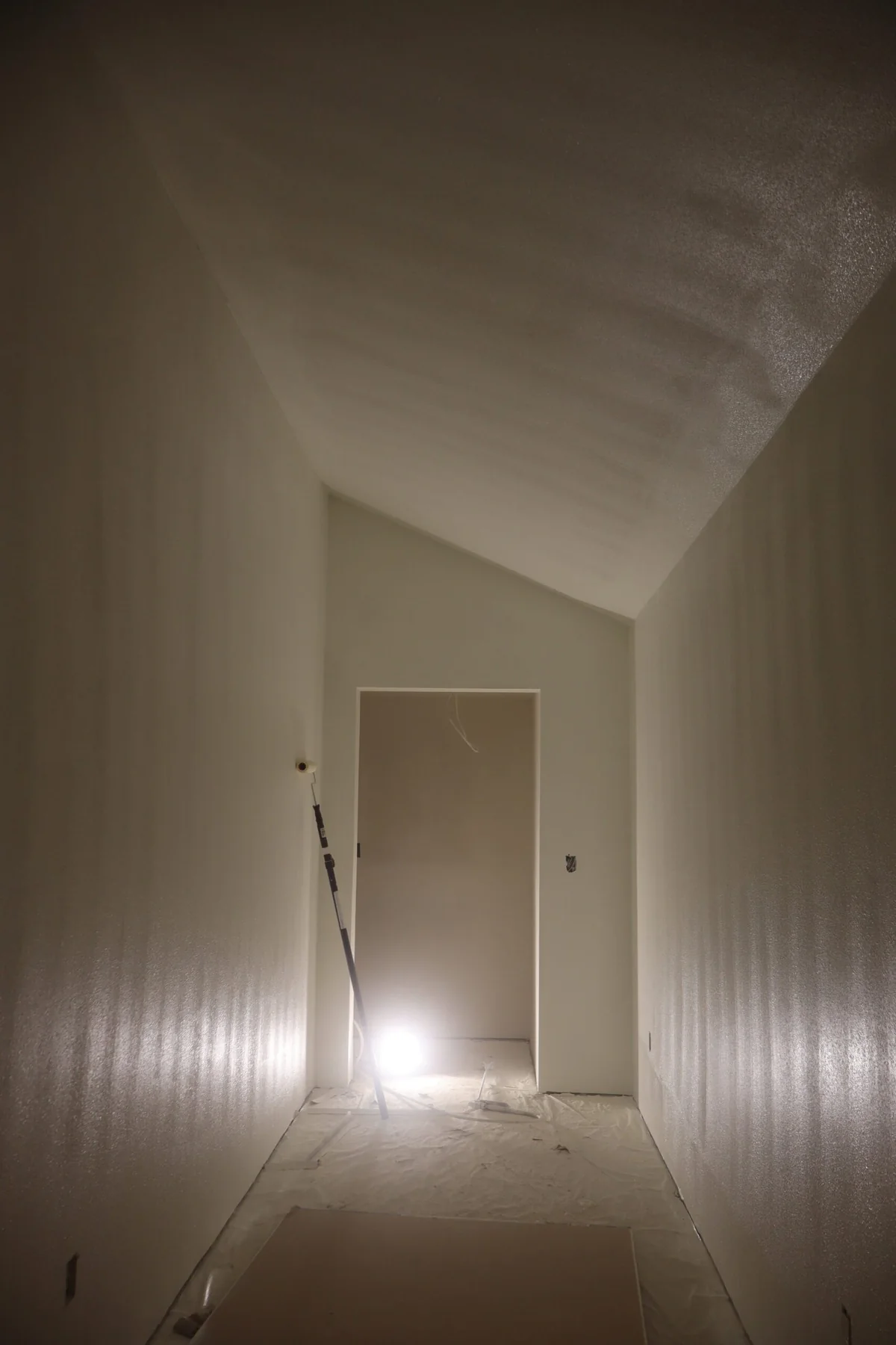 Long finished hallway with smooth walls and ceiling ready for paint